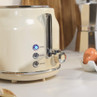Cream two-slice toaster with cancel, reheat and defrost buttons on kitchen counter
