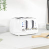 White four-slice toaster with chrome controls on kitchen counter
