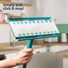 Turquoise flat mop head with disposable pad shown in hand, suitable for kitchen cleaning.