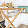 Bamboo clothes airer with laundry in modern kitchen