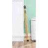 Folded bamboo step ladder stored upright beside kitchen cabinet and bin