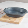 Round speckled grey baking tray on wooden board