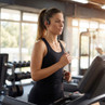 Woman in black sports vest running on treadmill in gym