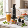 Black hand blender set with whisk, jug, and chopper attachment on kitchen counter