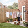 Retractable washing line in garden with clothes and woman hanging laundry