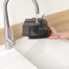 Removable dark water tank being filled under a kitchen tap