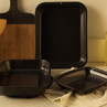 Set of three black speckled roasting tins on kitchen worktop