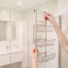 Chrome three-tier shower caddy hanging over glass shower screen