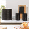 Set of three black tea, coffee, sugar canisters with matching bread bin on kitchen counter