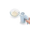 Blue hand mixer whisking batter in a glass bowl, product shown from side angle.