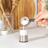 Stainless steel electric salt grinder being filled with coarse salt
