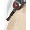 Vacuum cleaner cleaning dust from skirting board with crevice tool attachment