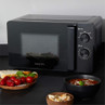 Black Salter microwave with control dials on kitchen counter, shown with soup and bread.