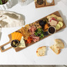 Charcuterie board with assorted cheeses, cured meats, crackers, olives, fruit and sliced bread