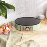 Green electric crepe maker on worktop with eggs, flour and milk, shown for kitchen product listing.