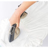 Steam iron smoothing white embroidered garment, handheld, close-up