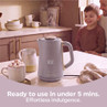 Mauve electric kettle with steam on kitchen counter; child and adult smiling in background