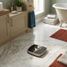 Gold and black bathroom scale on marble floor in modern bathroom setting