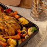 Roast chicken with rosemary and mixed vegetables in a baking tray