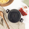Grey speckled casserole pot with glass lid and black handles, top view