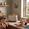Mocha two-slice toaster with toast on a kitchen worktop