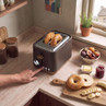 Brown two-slice toaster with bagels in slots on kitchen worktop