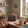 Brown two-slice toaster on kitchen counter with toast