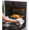 Tray of roast chicken with vegetables and roast potatoes in oven