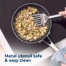 Overhead view of diced potatoes frying in a non-stick pan with metal spatula, emphasising easy clean.