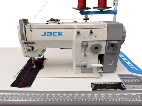 A close-up image of the Jack JK-20U-93Z Short Arm Zig-Zag Machine. The machine is set up for sewing and features adjustable zig-zag stitching, a precise stitch button, and a direct drive motor. The image showcases its robust construction, including the control panel and the convenient zig-zag width adjustment lever. This image is an illustration of the machine's quality and versatility for sewing and embroidery projects.