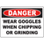 Danger sign instructing to wear goggles when chipping or grinding for safety in industrial environments.