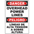 Warning sign for overhead power lines in English and Spanish, emphasizing safety in industrial environments.
