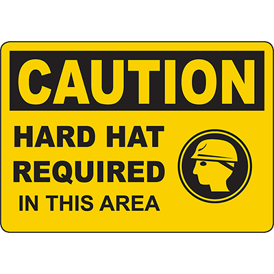 Bright yellow caution sign indicating hard hat requirement for safety in industrial areas.