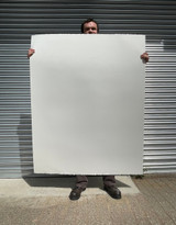 Tall artist holding a sheet of giant 400gsm watercolour drawing paper to demonstrate scale