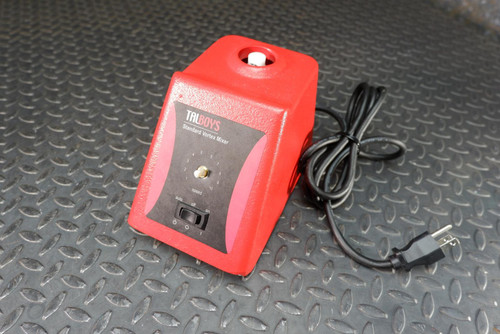 Red housing with "TALBOYS Standard Vortex Mixer" label on front panel. Black control panel shows toggle switch and speed pot. Knob and mixing cup absent. Power cord attached.