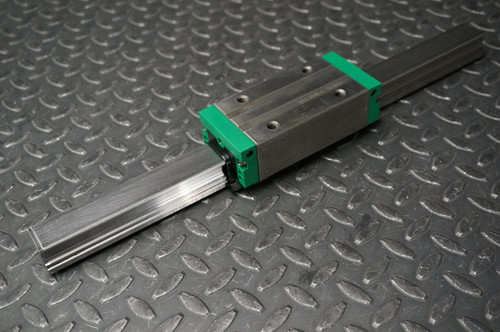 INA KWVE30BSLV1G3 linear bearing block mounted on a 400mm slide rail on a diamond plate surface.