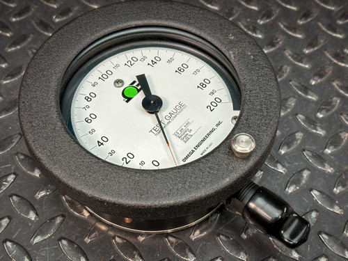 This image shows an Omega pressure gauge with a range of 0-200 PSI. The gauge has a black casing and a white face with a clear needle indicator, marked as a 4.5" Type T model, PGT-45L-200. It is placed on a textured metal surface.