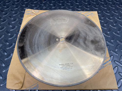 Norton 10-inch diamond cut-off wheel, M4D80-N50M-1/8, showing 6115 MAX RPM rating and arbor hole.