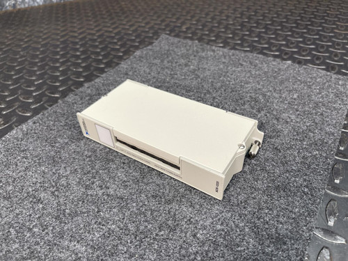 Off-white enclosure with front slot opening and side latch intact; no visible chips, cracks, or heavy wear on housing surfaces.
