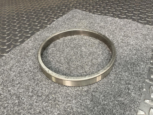 Timken L327210 tapered roller bearing outer race (cup) resting on a gray felt surface.