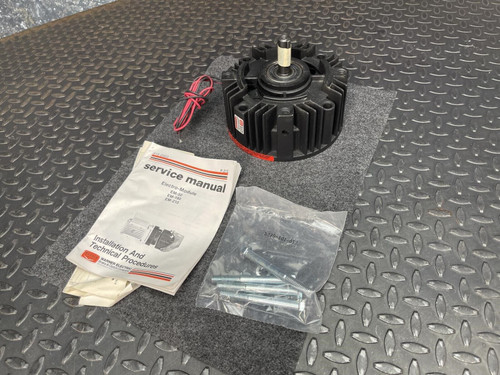 Warner Electric EM-50-20FBB Electromagnetic Brake from Obtainium Science and Surplus shown with installation manual, hardware bag, and wiring on a textured black floor mat.