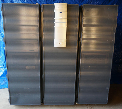 Front view of a vintage Cray J90 'Jedi' Vector Processor Supercomputer model J916. The setup features three tall, black metallic cabinets with ventilated doors, centered by a distinctive white and blue tower with the Cray logo, displayed in a warehouse with a blue tarp background.