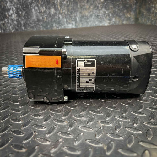 A black Bodine 42A4BEPME4 gearmotor, featuring a 115VDC electric motor, 21 RPM output, and 120:1 reduction ratio, is showcased horizontally on a dark industrial diamond plate surface. An orange warning tag is attached near the shaft, which is protected by a blue net. The product's silver nameplate clearly displays 'BODINE Electric Company' and 'Gearmotor' details, with a handwritten 'Ser  4116' visible on the side of this robust DC power transmission unit.
