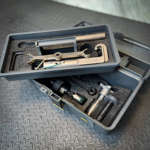 Two stacked black toolboxes on a textured metal floor, containing precision metal instruments with foam padding. Conval TK5D-C-S-1 Tool Kit for Size 5D Valves from Obtainium Science and Surplus.