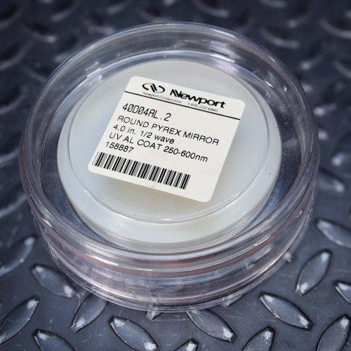 Unused Newport 40D04AL.2 Borofloat Mirror 4 Inch λ/2 Flatness, 250-600nm from Obtainium Science and Surplus, shown in its round protective case with product label visible.