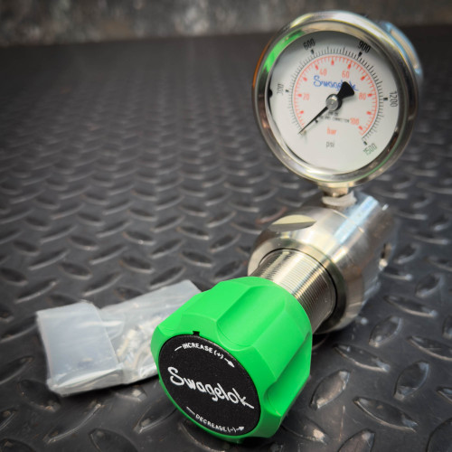 Swagelok KPB1L0D422PD00A0 back-pressure regulator with green adjustment knob and pressure gauge on diamond plate.