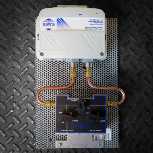 Setra 231 Multi-Sense wet differential pressure transducer connected to its manifold by copper tubing.