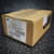 Sealed cardboard box with a 3M product label for 6600-S LC Simplex Hot Melt Fiber Optic Connectors from Obtainium Science and Surplus, sitting on a black textured surface.