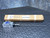 Unit partially removed from original kraft cardboard box, handwritten inventory tag "SS7427" visible. Switch body and spring rod actuator intact.