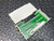 An open view of the National Instruments NI SCXI-1302, 50-Pin Terminal Block from Obtainium Science and Surplus, revealing its internal green circuit board and connections. It is placed on a textured metal surface.